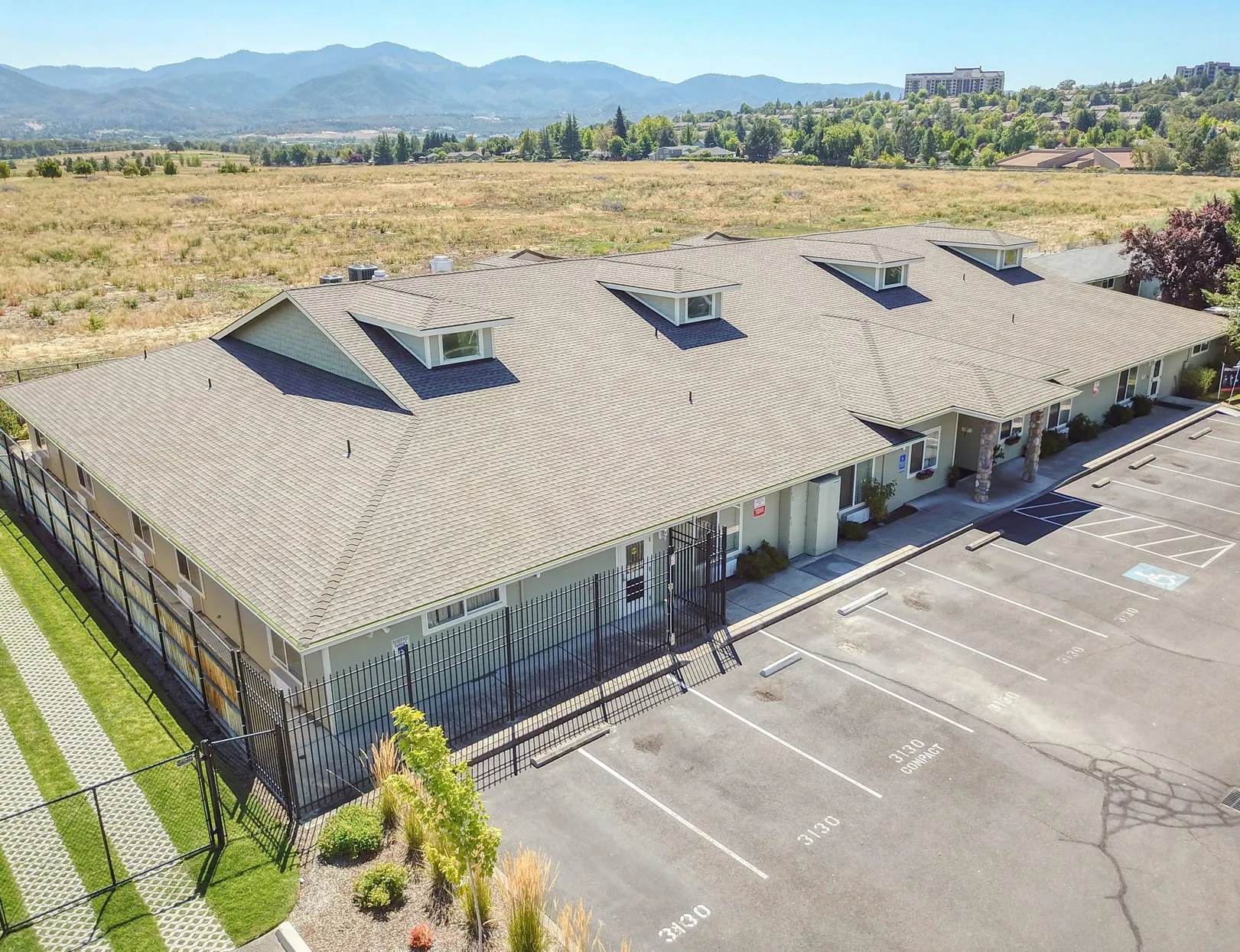 Aerial view of West Wind Assisted Living facility surrounded by open fields and mountains